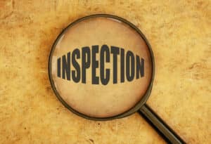 Magnifying glass focusing on the word inspection